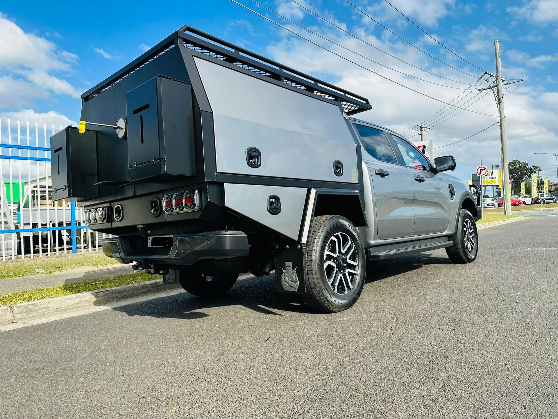 Gray Ford Ranger Pickup Truck With a Custom Camper Shell Parked on Asphalt Next to a Street — PT Canopy In Ipswich, QLD
