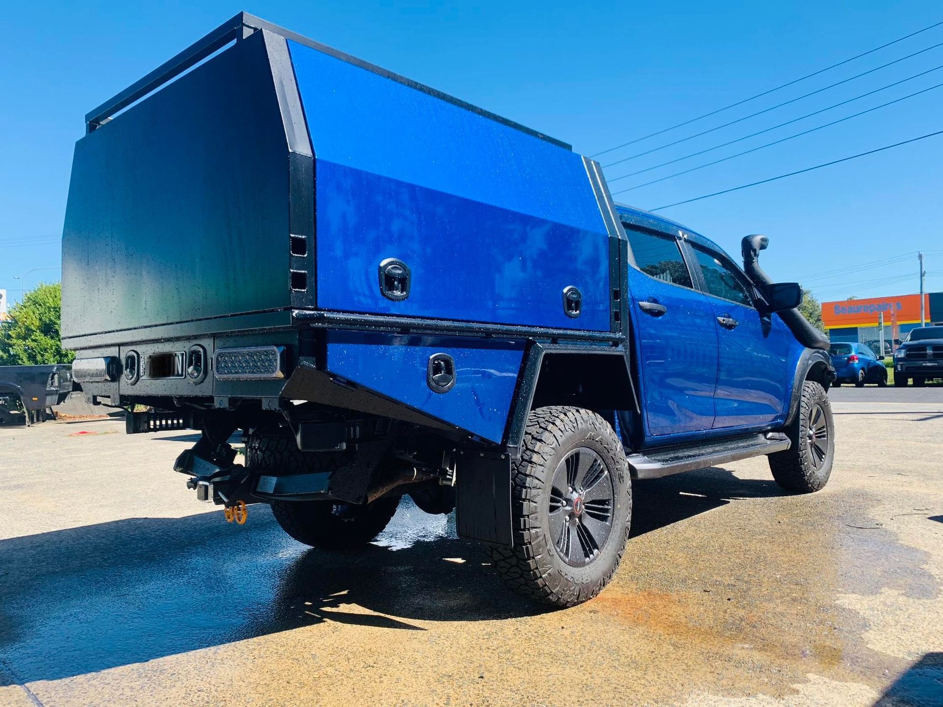 Blue Pickup Truck With a Custom Black Utility Bed and Large Off-Road Tires Parked — PT Canopy In Slacks Creek, QLD
