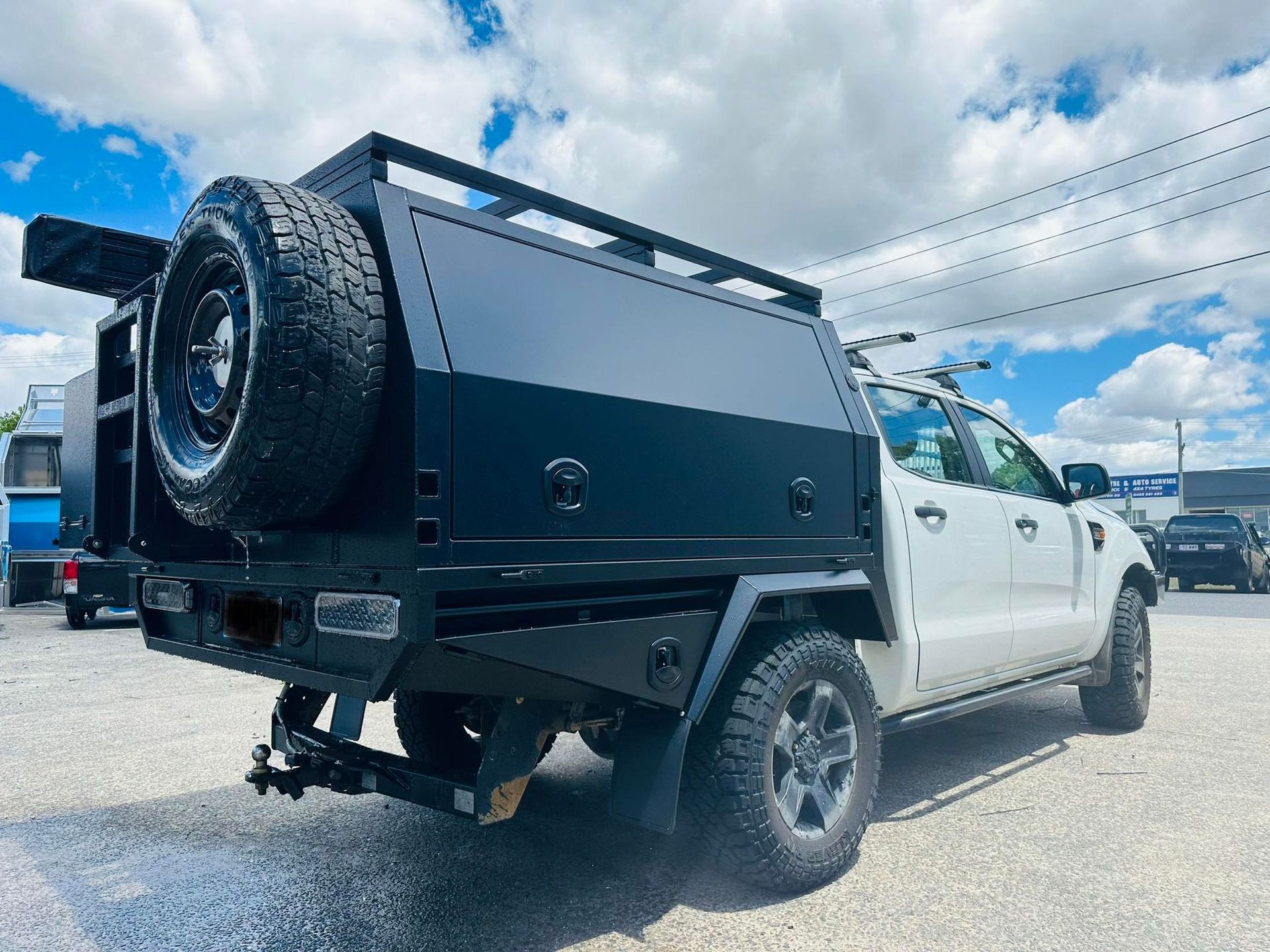 Black Utility Truck Bed With Spare Tire Mount on a White Ford Ranger — PT Canopy In Slacks Creek, QLD