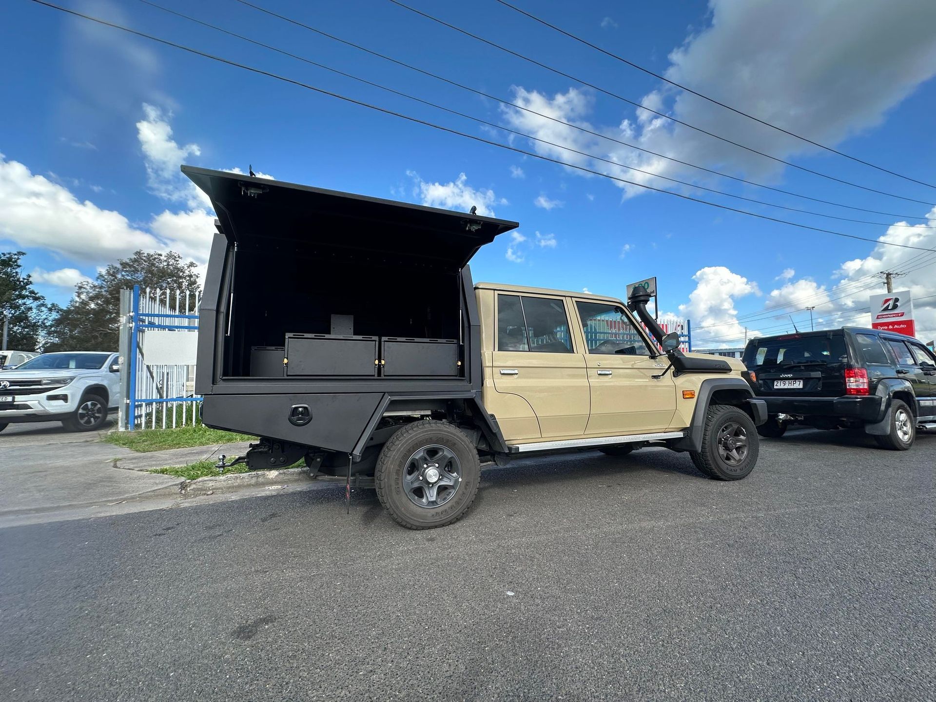 Tan Utility Truck With a Black Cargo Box and Open Lid Parked on a Road — PT Canopy In Slacks Creek, QLD