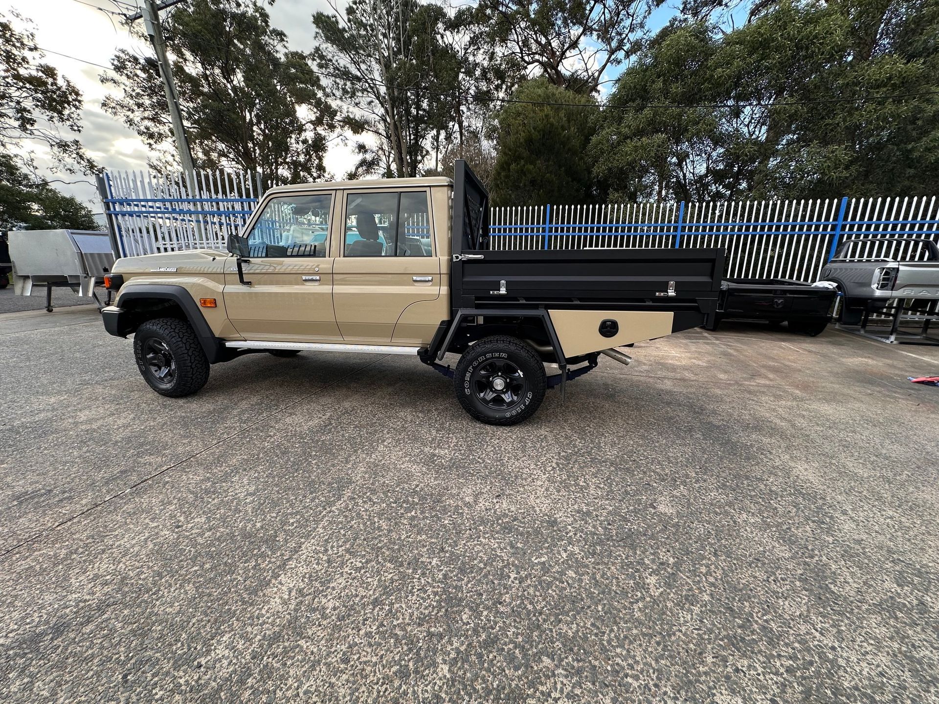 A Tan Pickup Truck With a Black Flatbed Parked on Gravel — PT Canopy In Slacks Creek, QLD