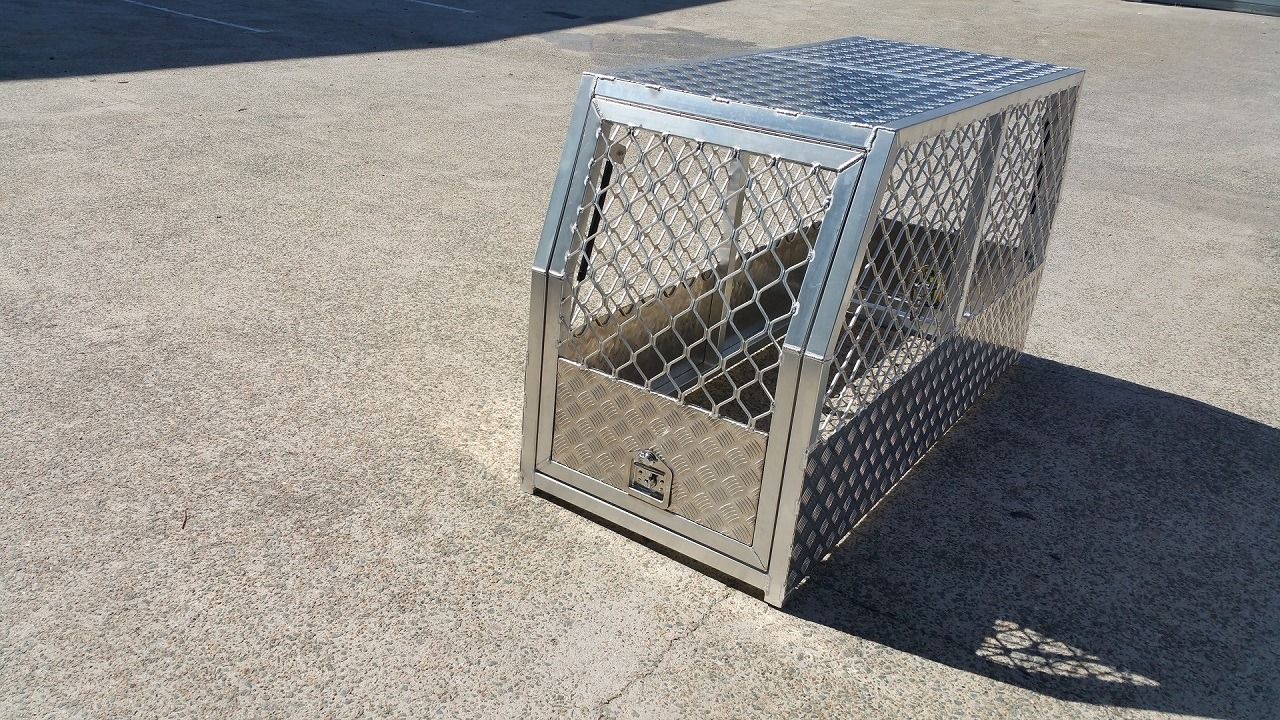 Metal Dog Crate With a Sloped Roof and Wire Mesh Sides on a Concrete Surface — PT Canopy In Slacks Creek, QLD