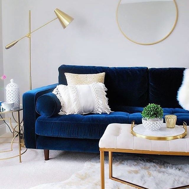 A living room with a blue couch and a white coffee table