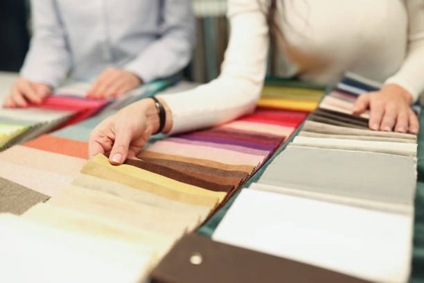 Two people are looking at fabric samples on a table