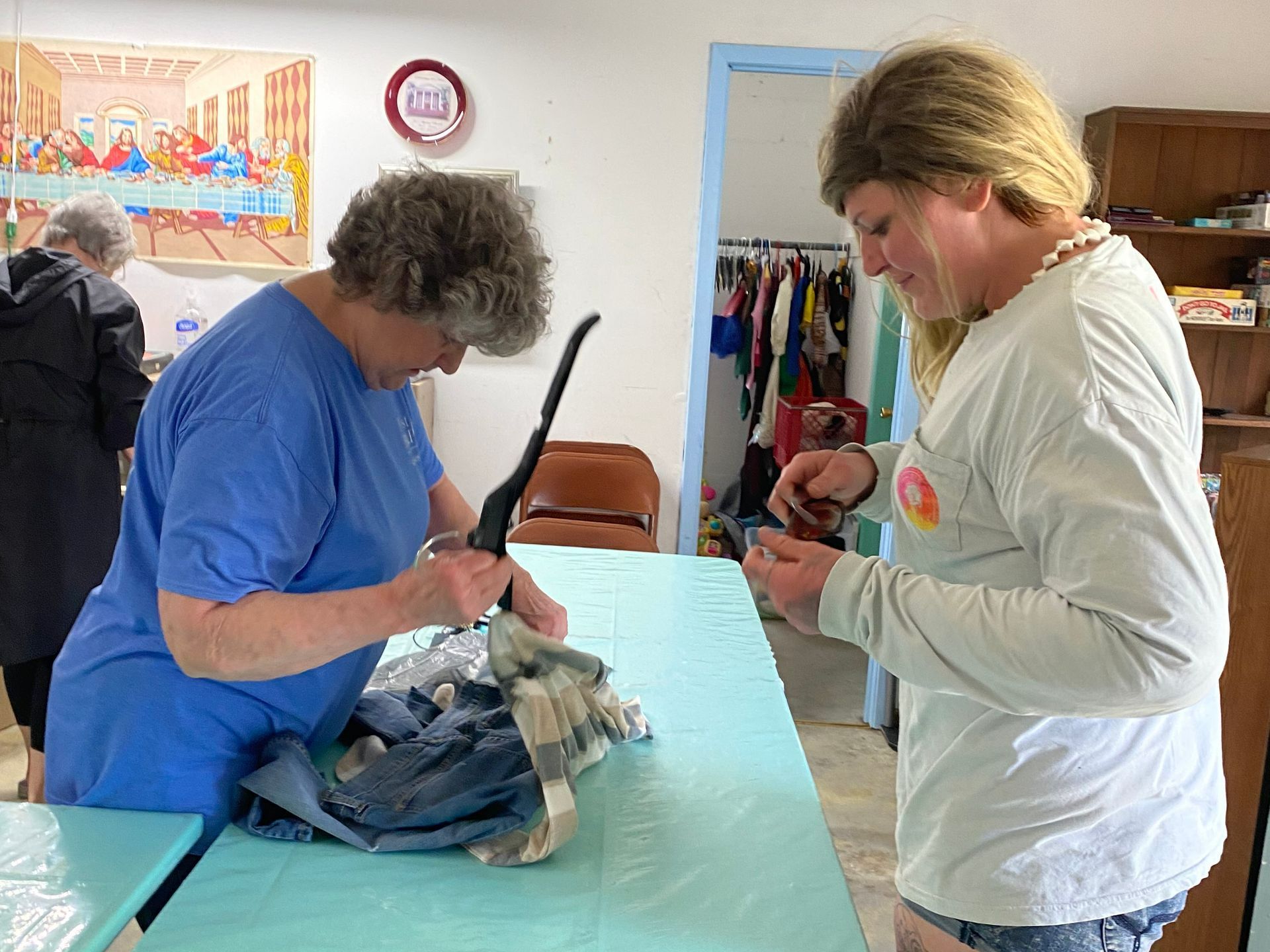 Two women are sitting at a table looking at something