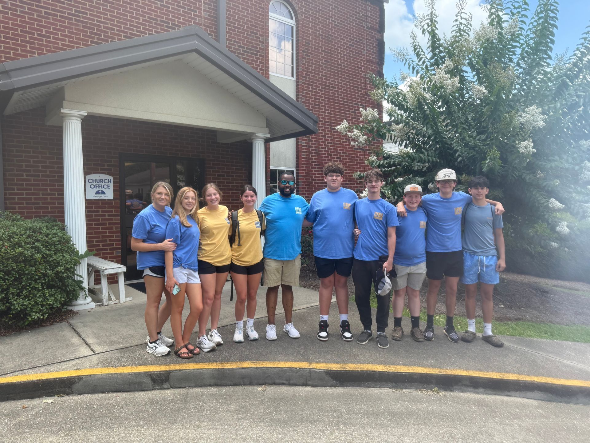 A group of people are posing for a picture in a hallway.