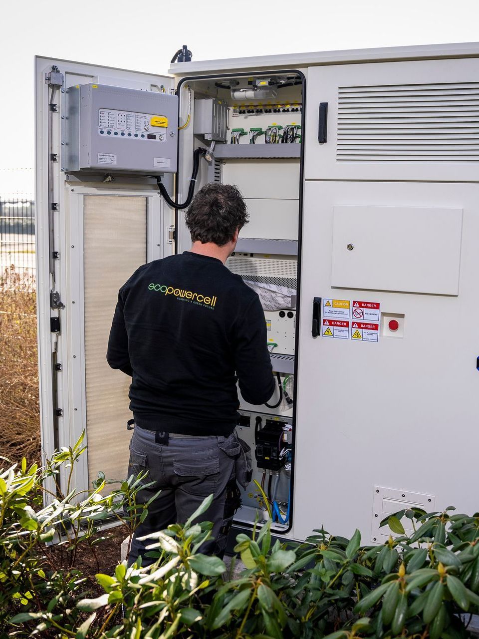 Een witte kast met de deuren open en een heleboel batterijen erin