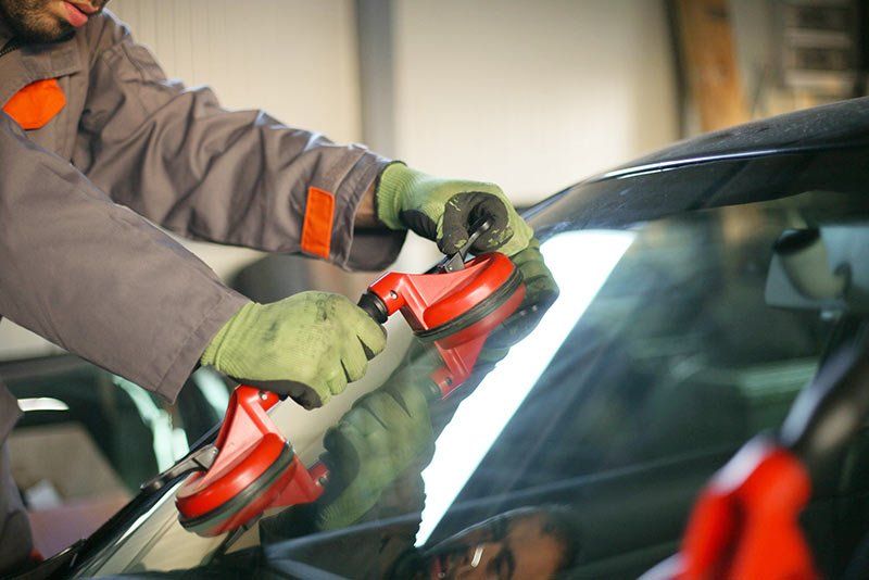 Vehicle Glass Repair — Worker Installing New Windshield to the Car in Louisville, KY