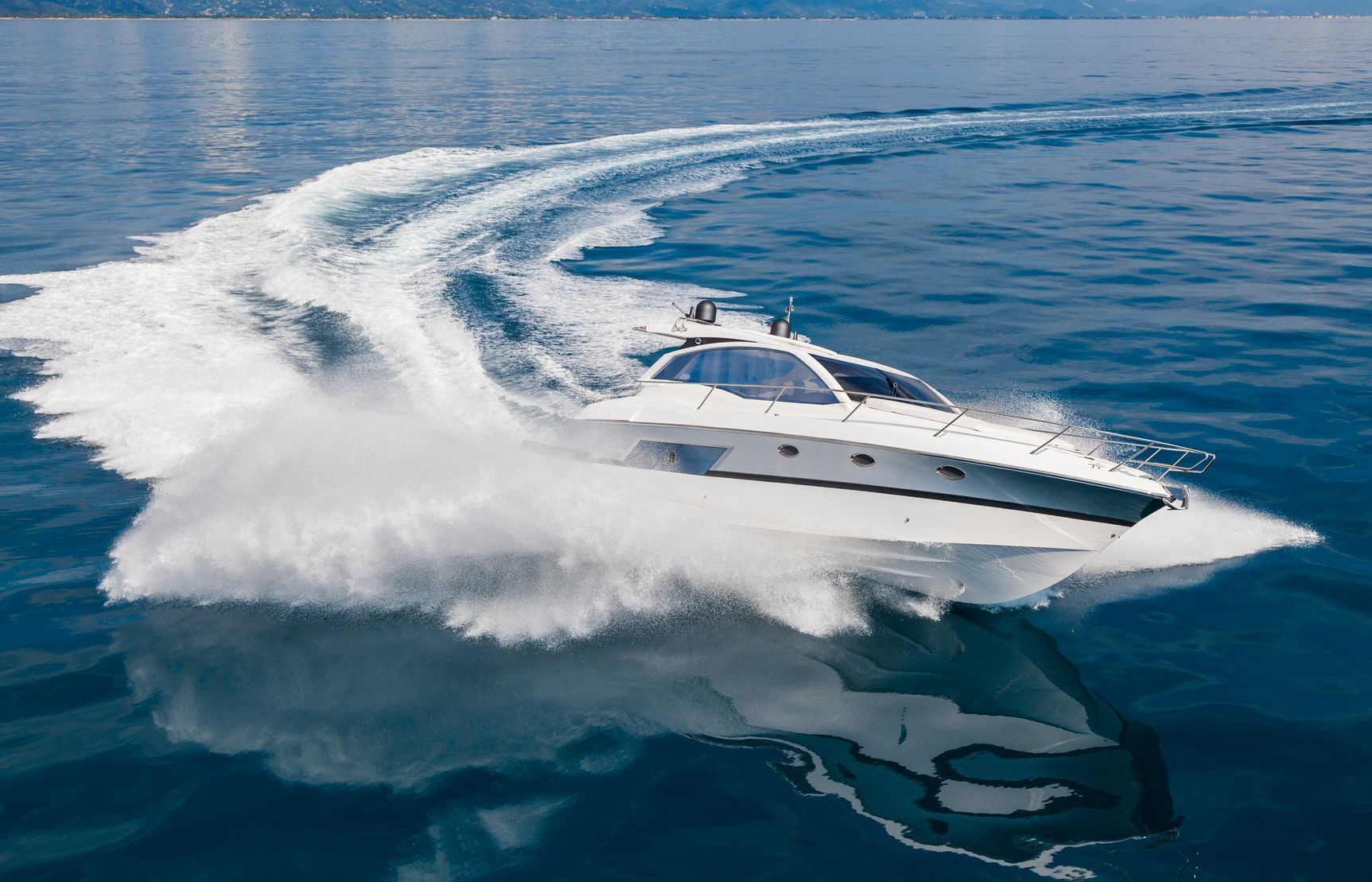 A white boat is floating on top of a body of water