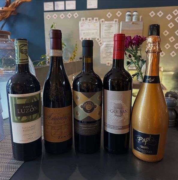 Five wine bottles on a counter