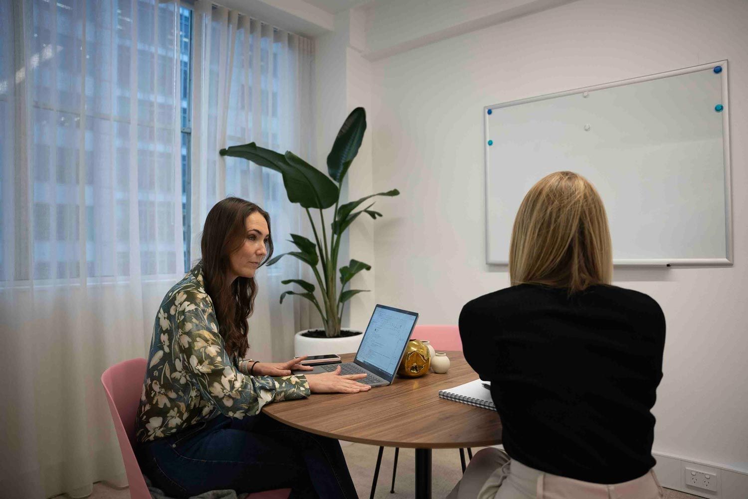 Two tech & engineering recruiters are sitting at a table with a laptop
