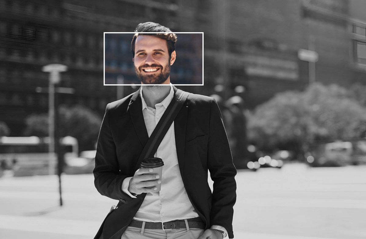 A tech & engineering recruitment specialist in a suit is holding a cup of coffee