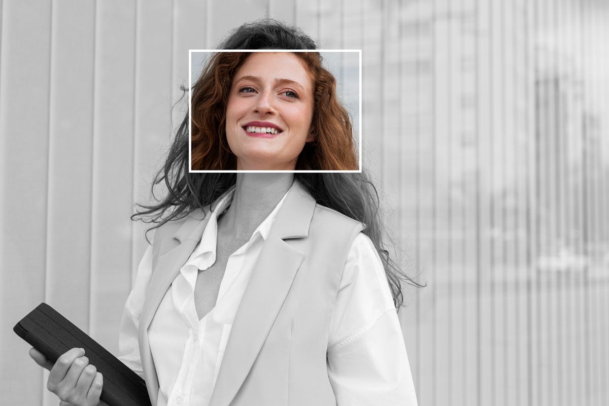 A specialist recruiter in a suit is smiling and holding a clipboard