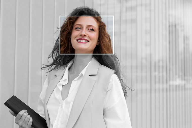 A specialist recruiter in a suit is smiling and holding a clipboard