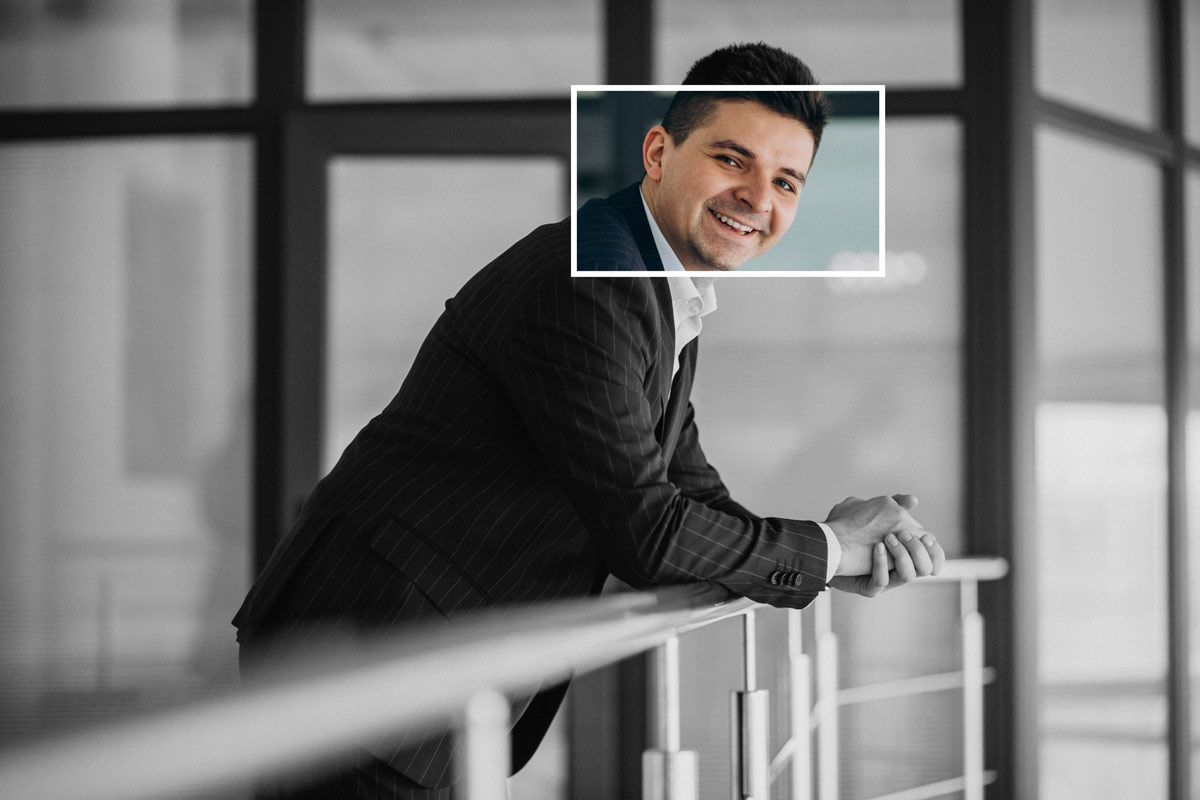 A talent recruitment specialist in a suit is leaning on a railing