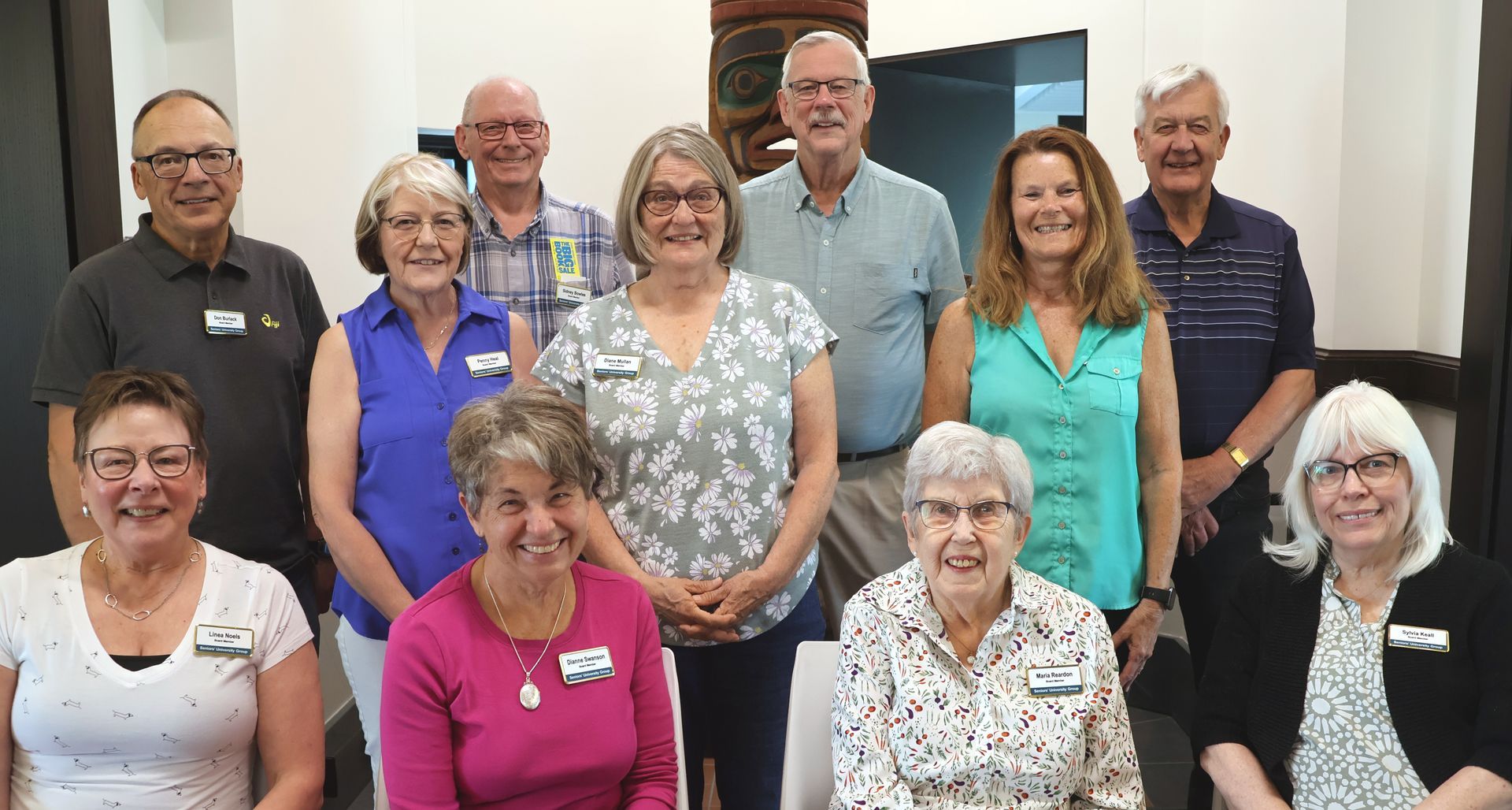 The SUG Board is posing for a picture in front of a building.