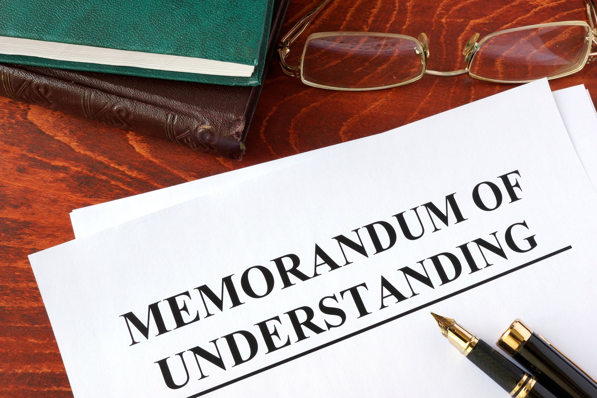 A memorandum of understanding is sitting on a wooden table.