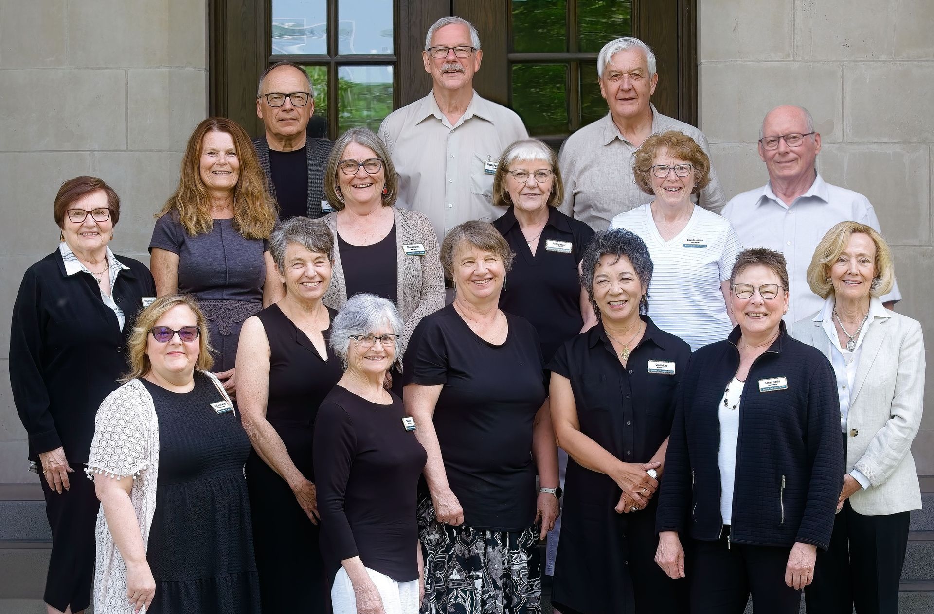 The SUG Board is posing for a picture in front of a building.