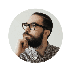 A man with glasses and a beard is thinking about something