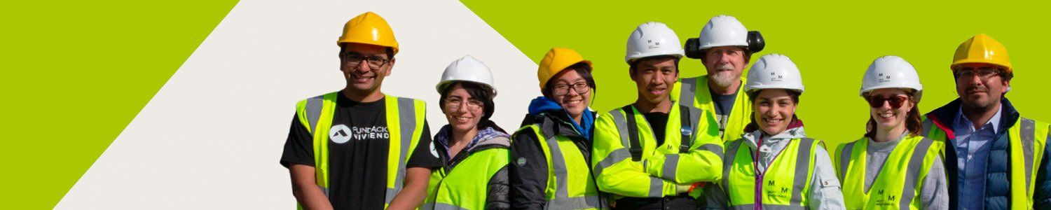 A group of people wearing hard hats and safety vests are posing for a picture.