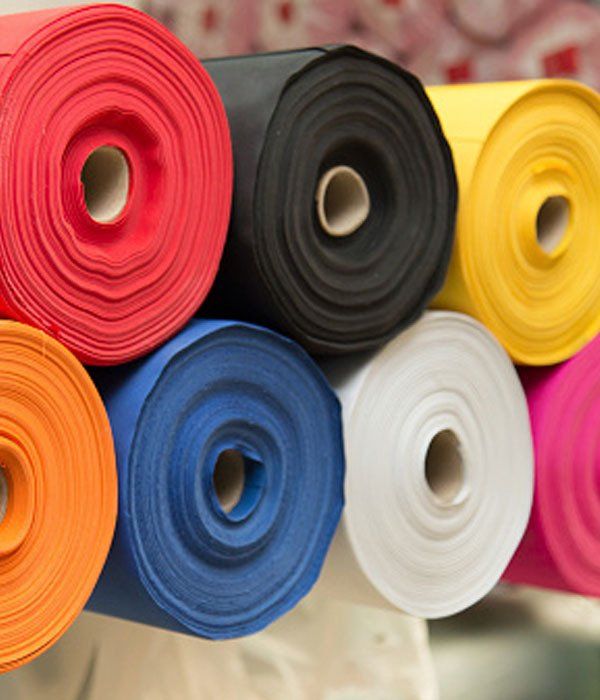 A bunch of rolls of fabric are stacked on top of each other