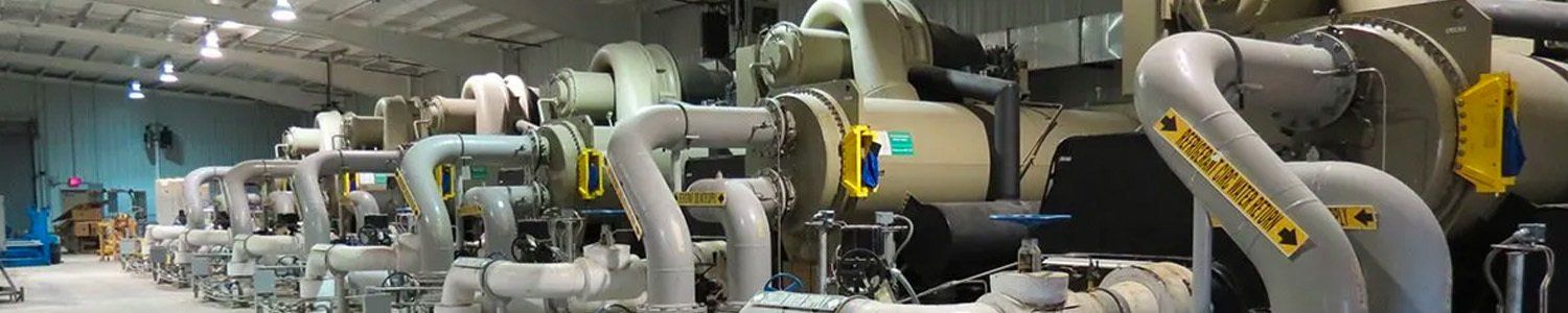 A row of compressors are lined up in a warehouse.