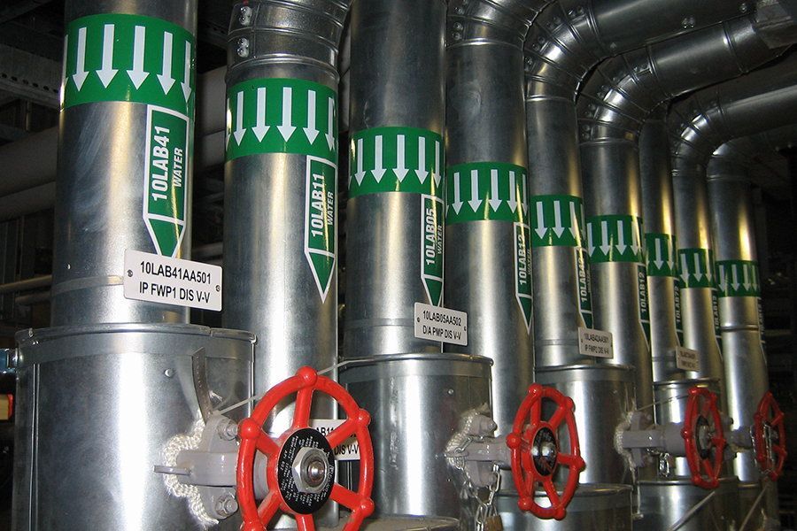 A row of metal pipes with green labels that say tolab4t