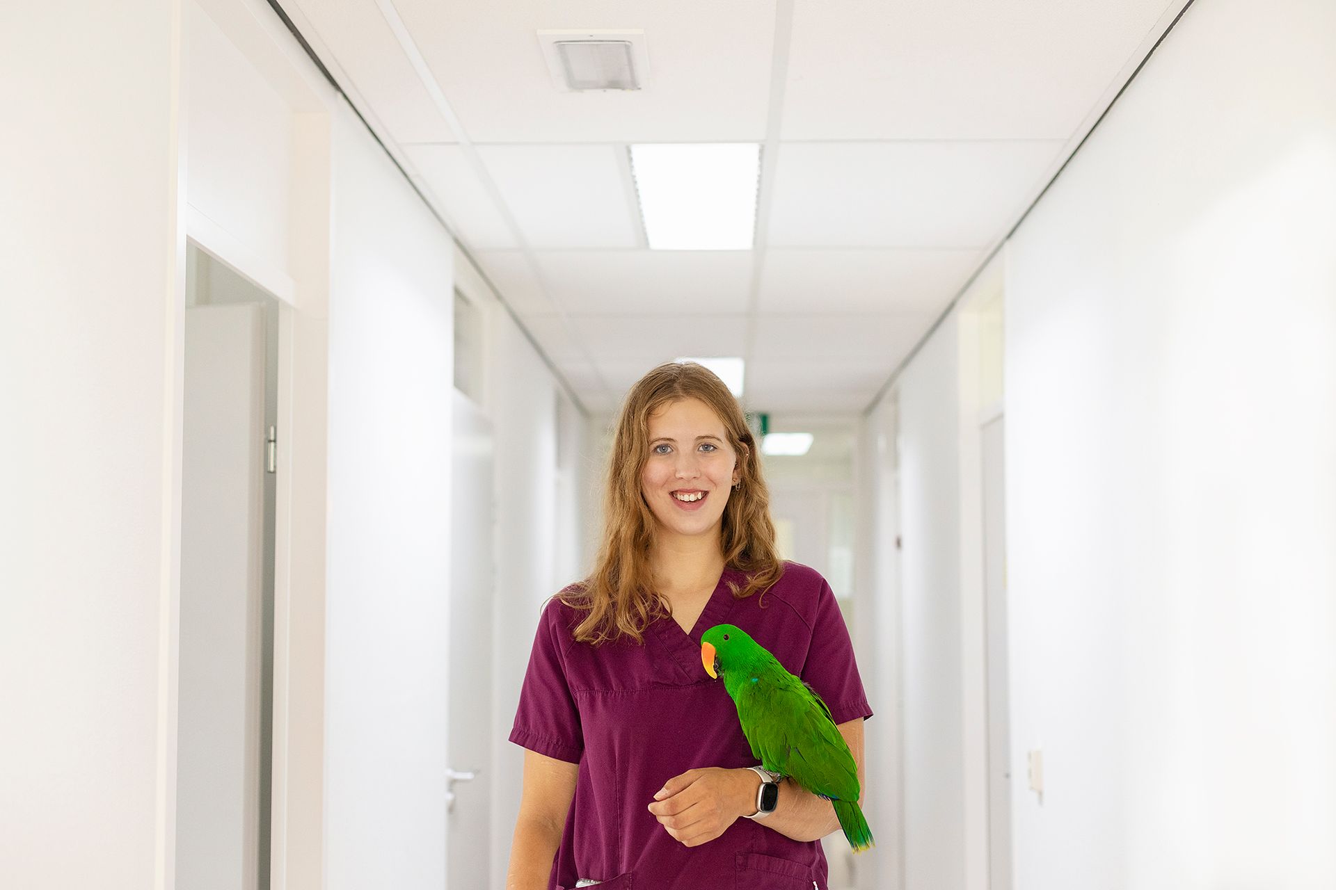 Een vrouw houdt een kat vast in een gang