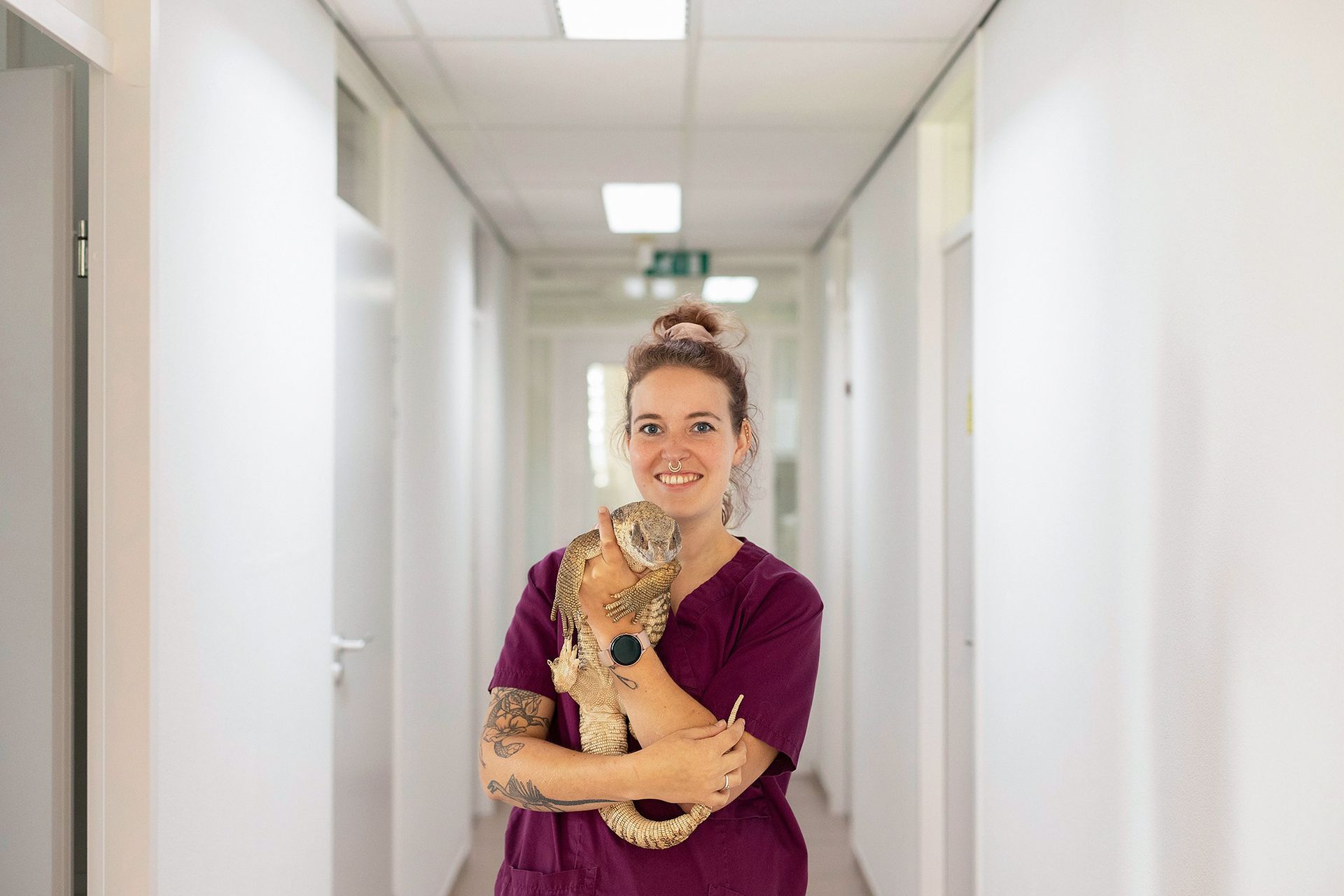 Een vrouw houdt een kat vast in een gang.