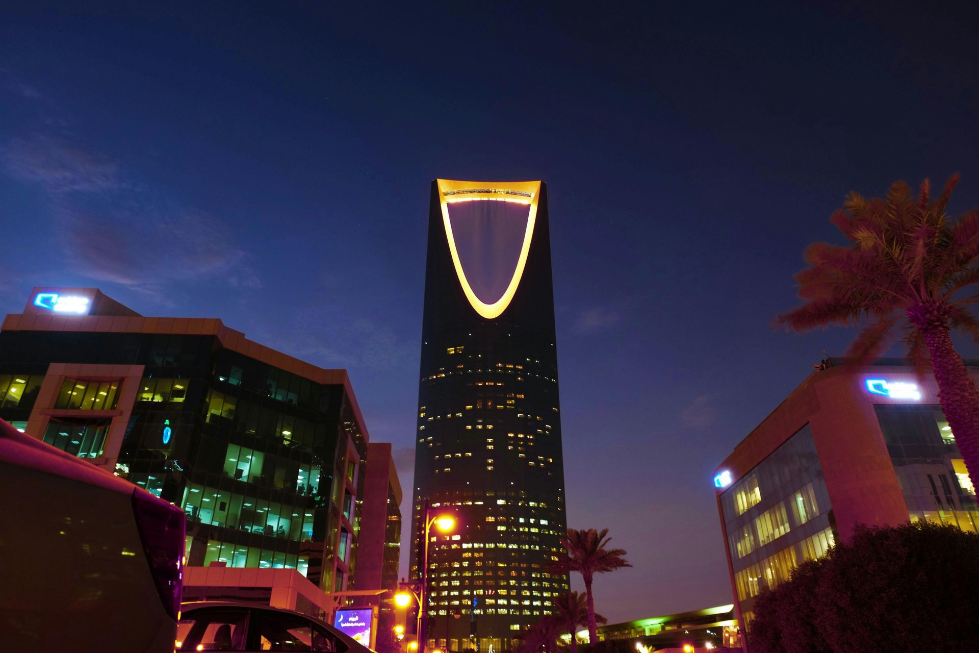 A tall skyscraper at night with an illuminated, gold-colored top in Riyadh, Saudi Arabia.