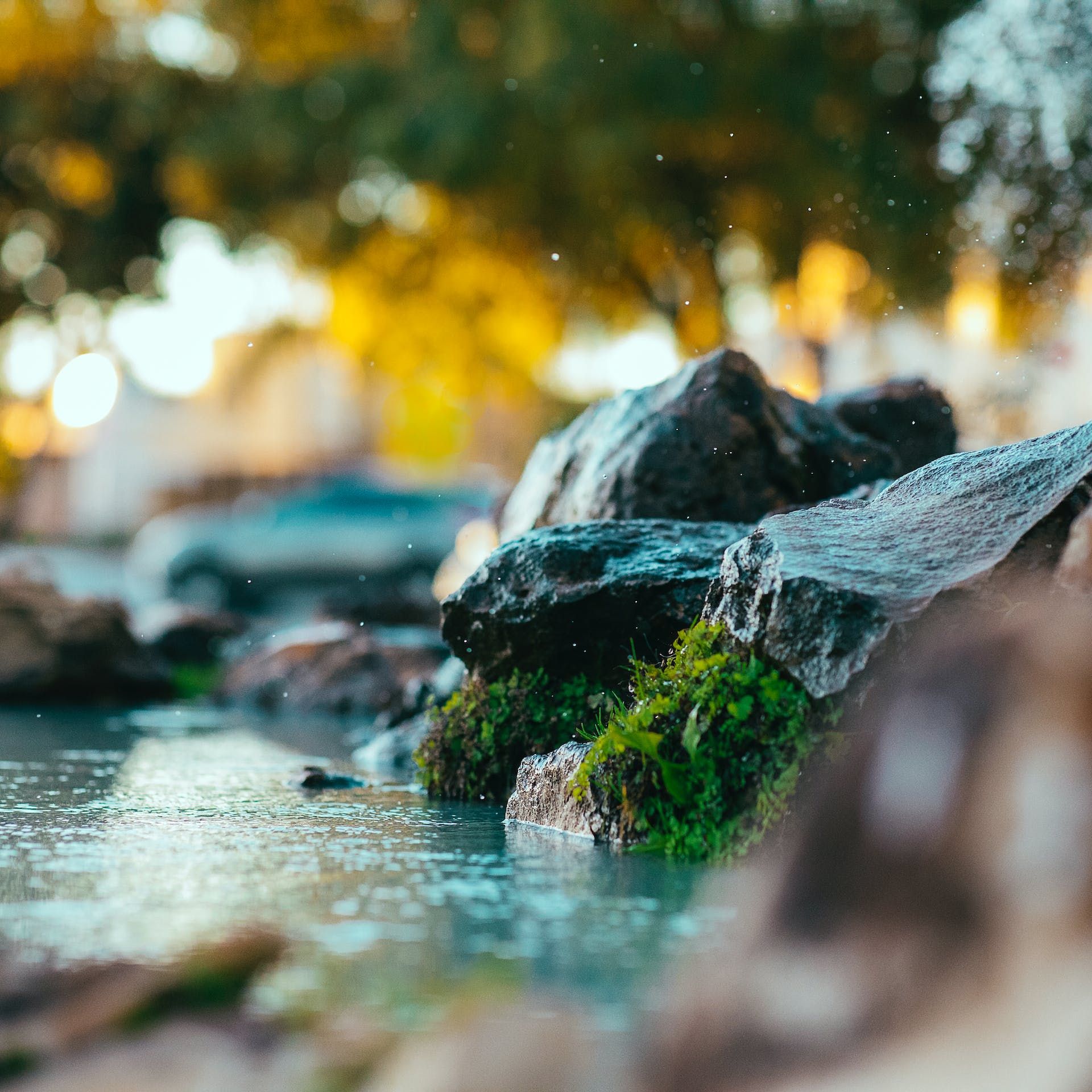 A group of rocks sitting next to a body of water.