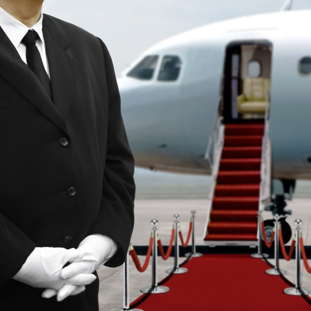 a man in a suit and tie stands in front of an airplane