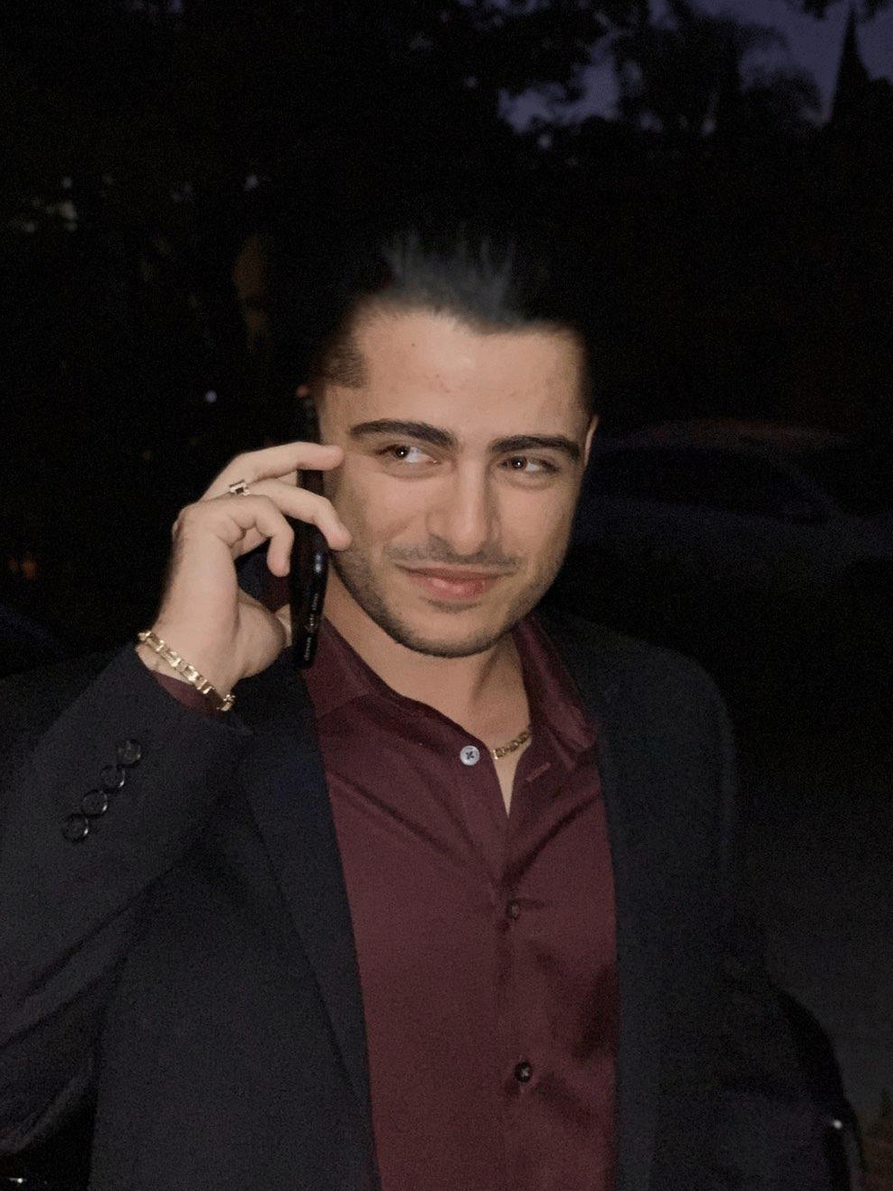 a man in a suit is talking on a cell phone