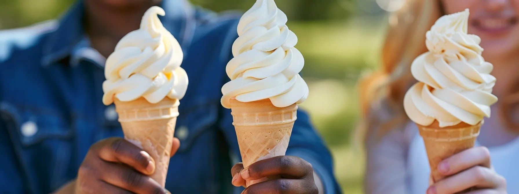 three kids holding soft serve ice cream in a cone