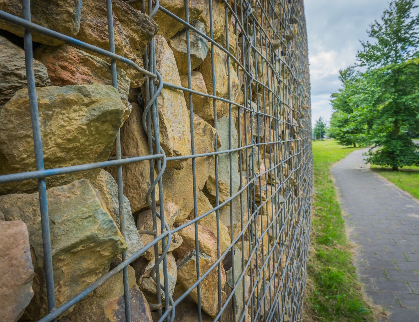 a stone wall with a metal fence around it