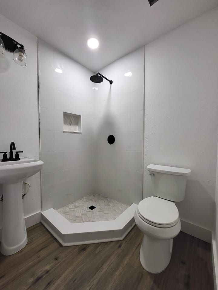 A bathroom with a toilet a sink and a shower