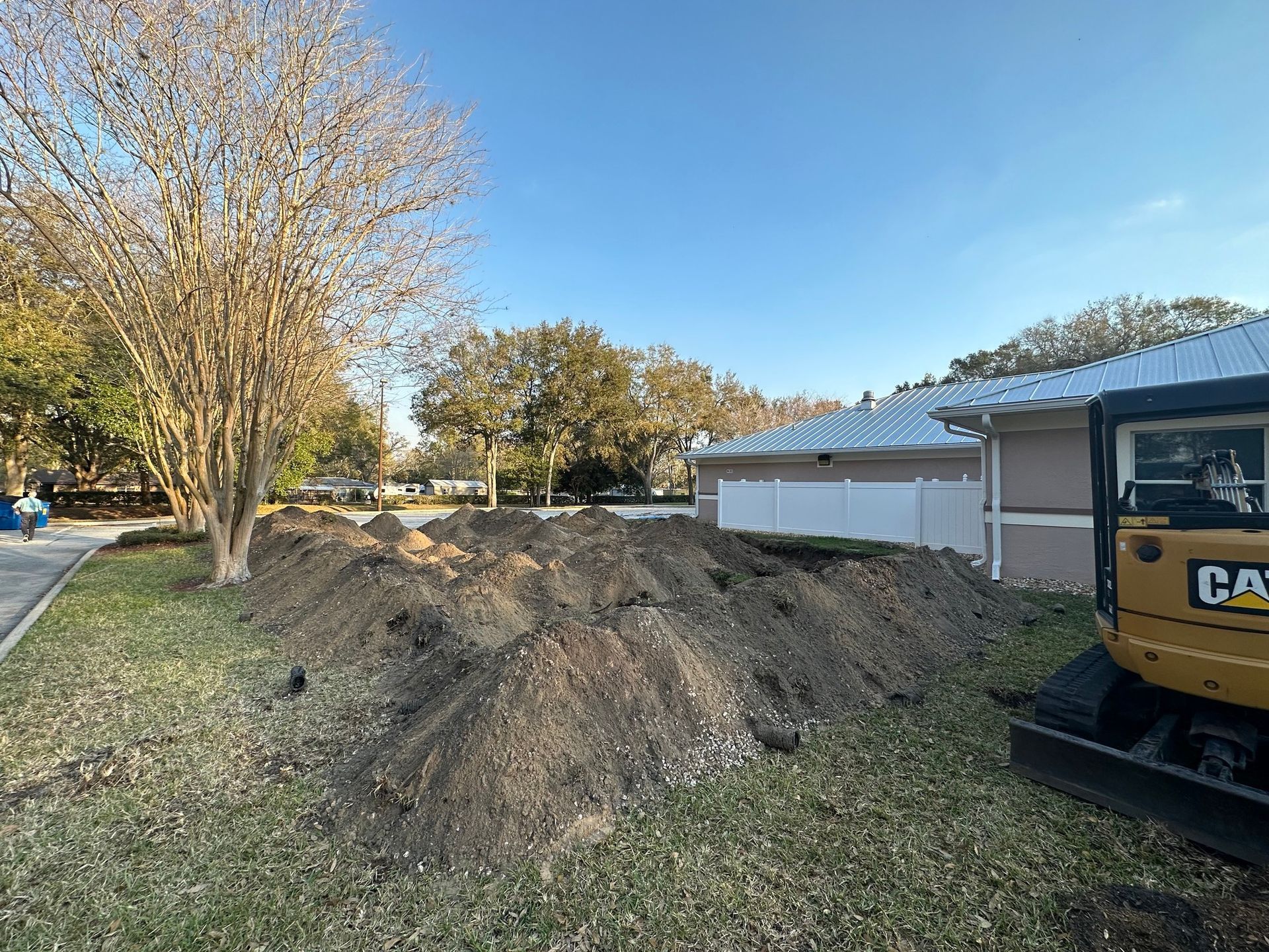 A large pile of dirt is sitting in front of a house.