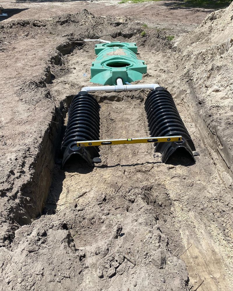 A septic tank is being installed in a dirt field.