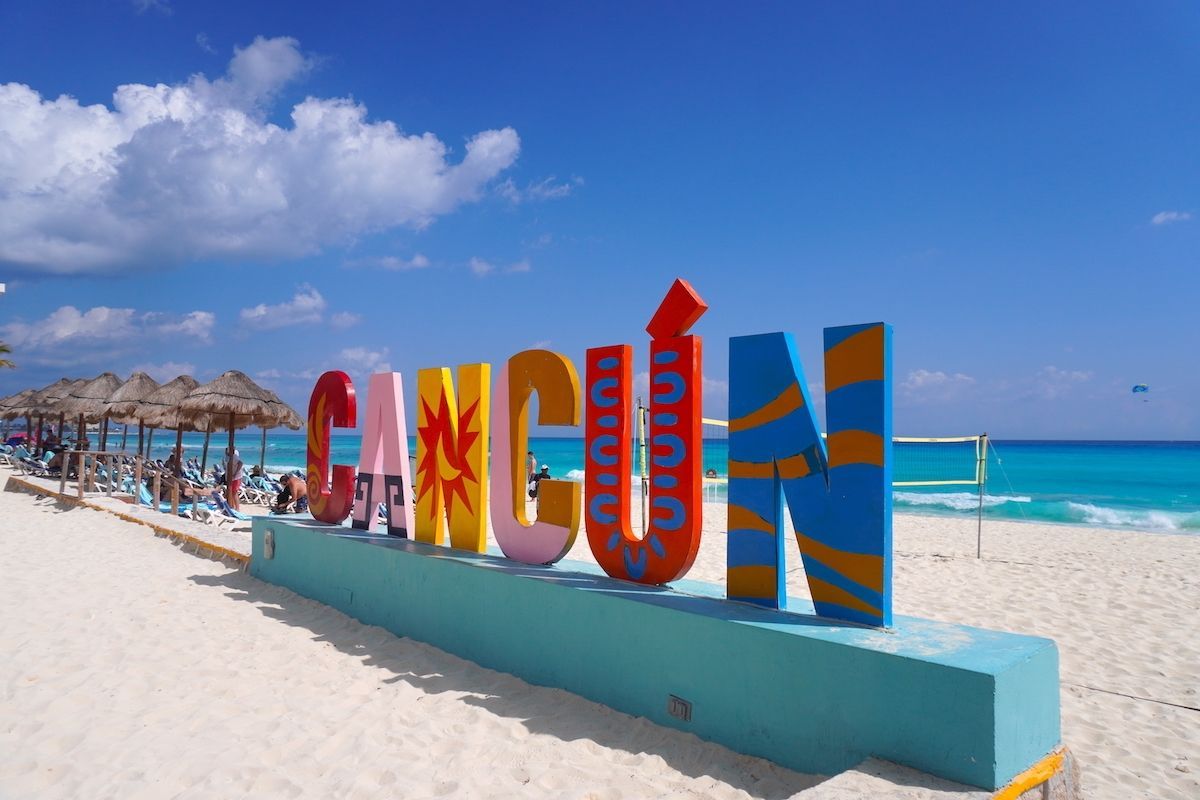Un cartel en una playa que dice Cancún.