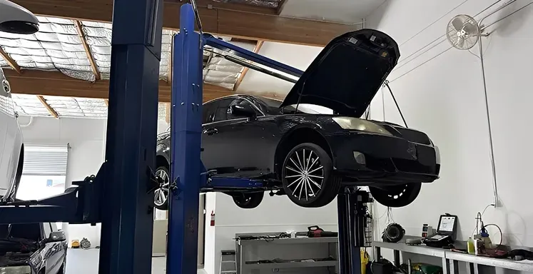 Inside our garage with black car raised up in Sacramento, CA | Two Rivers Auto Tech