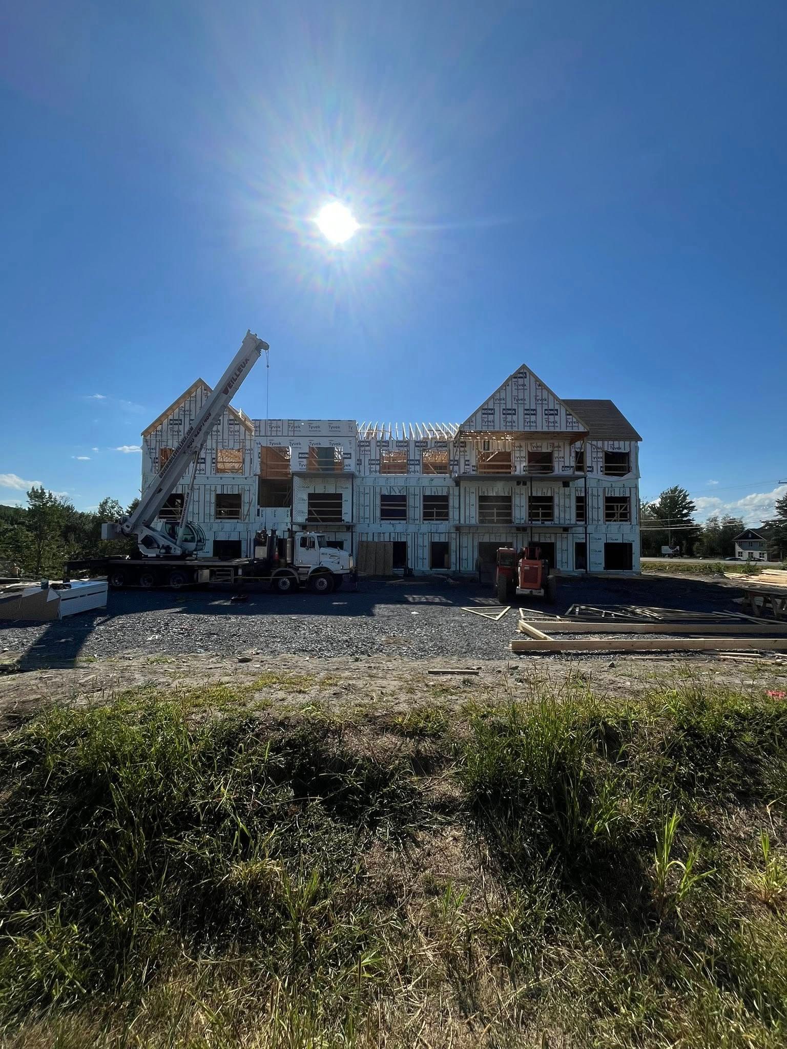 Bâtiment en construction avec une grue par une journée ensoleillée.