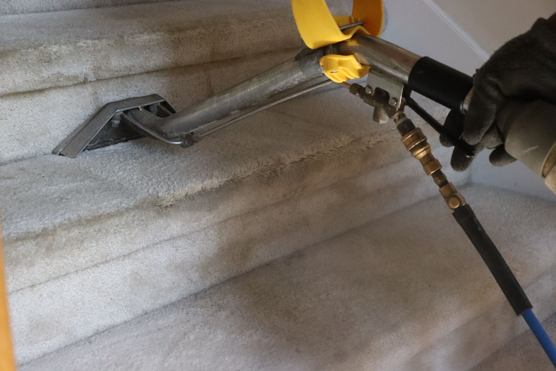 A person is cleaning a carpeted staircase with a machine.