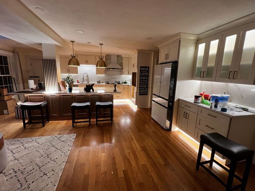 A kitchen with hardwood floors and white cabinets is being remodeled