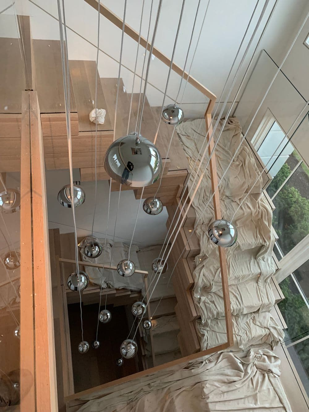 An aerial view of a staircase with a lot of lights hanging from the ceiling