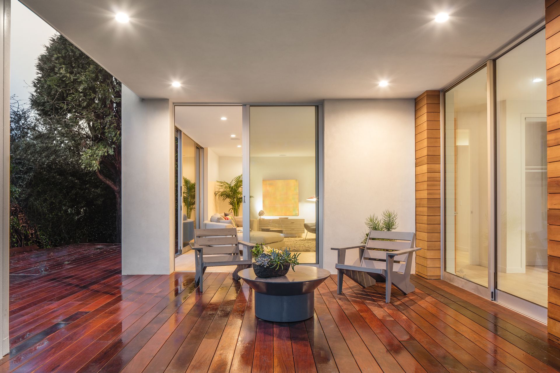 A wooden deck with chairs and a table in a house