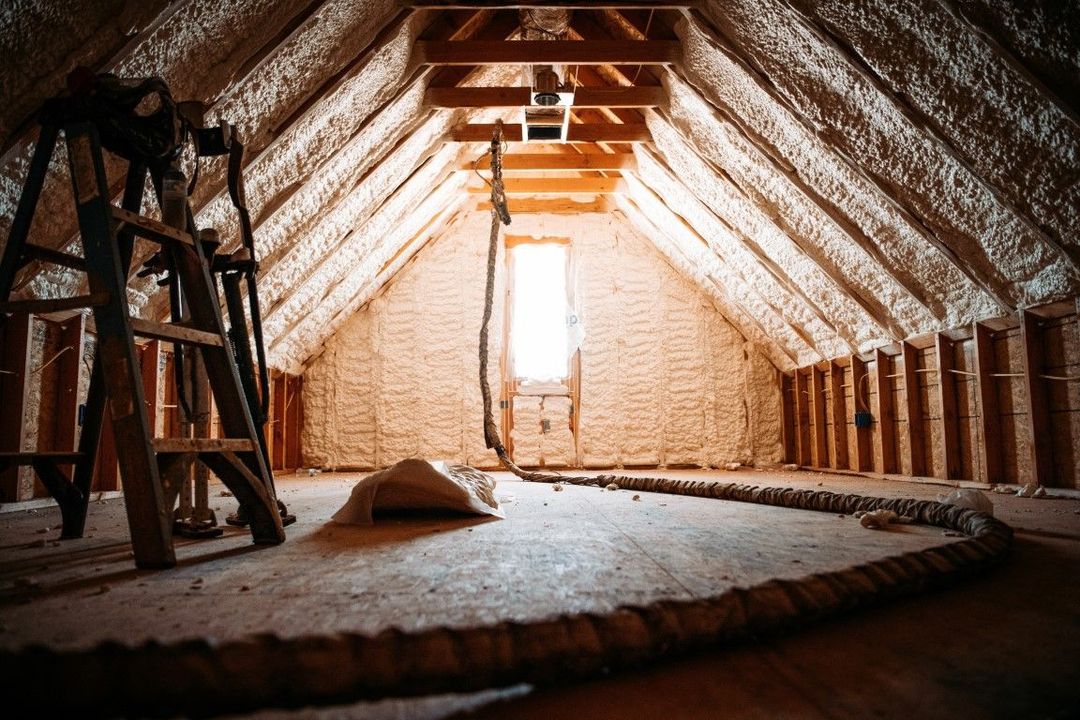 A worker in yellow protective gear is installing a wooden roof.