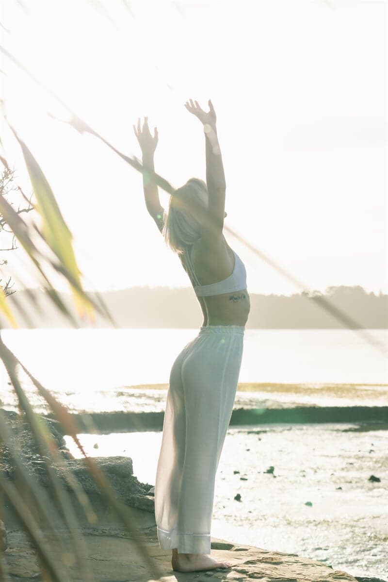 Woman Doing Yoga Besides the Ocean — Naturopath in Toowoomba, QLD