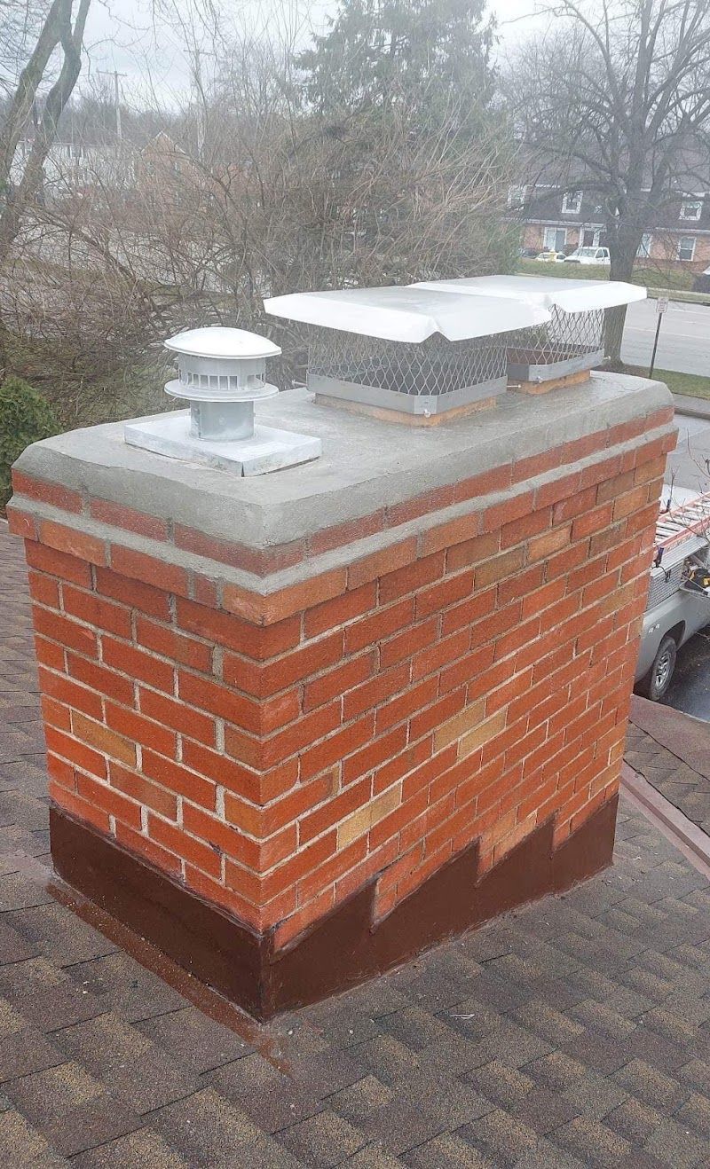 A brick chimney is sitting on top of a roof.