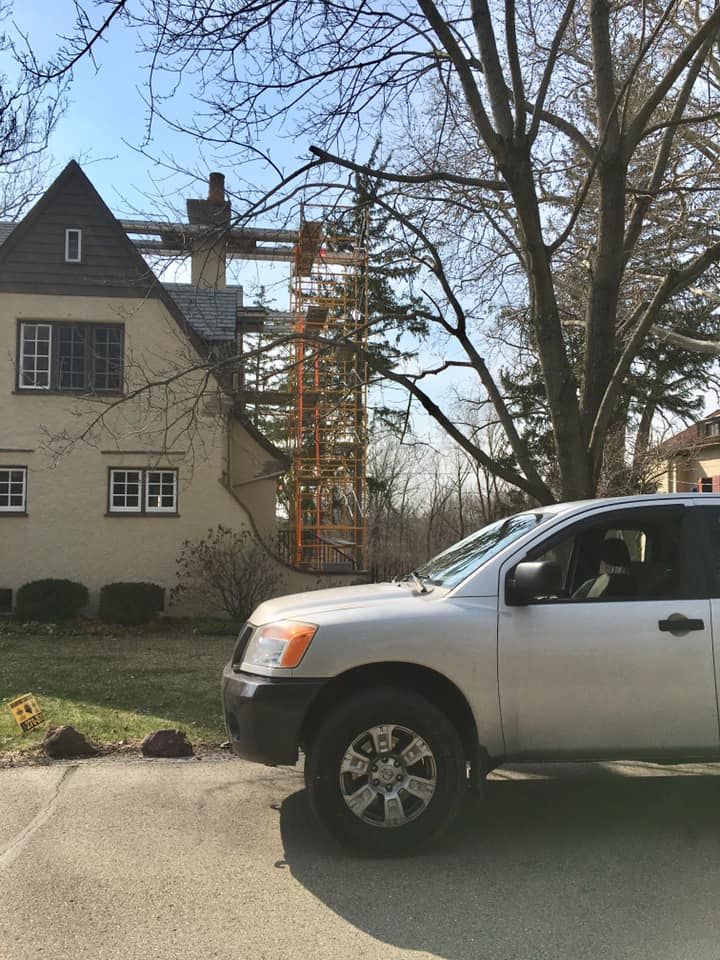 A silver suv is parked in front of a house under construction