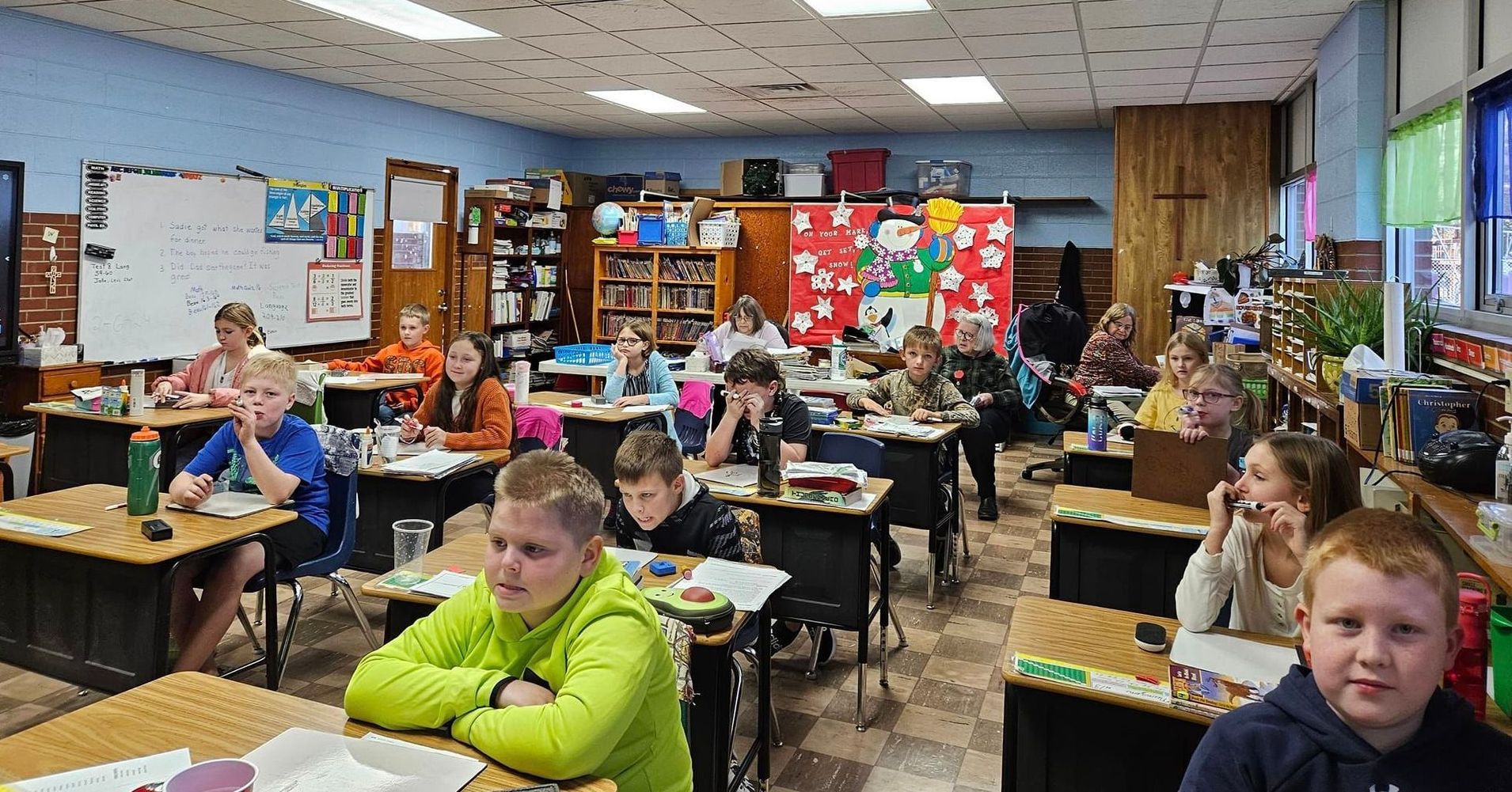 A group of children are sitting at desks in a classroom.